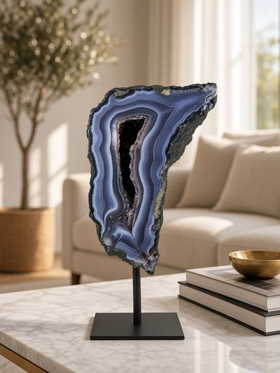 Verticaal gezaagde blauwgrijze agaat met open kristalader op een marmeren blad