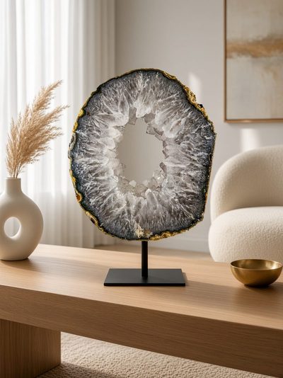 Naturel grijs-witte agaatschijf met open kristalring op een houten salontafel